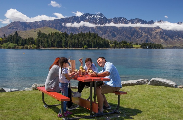 Personas junto a un lago y montañas en Nueva Zelanda